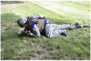Soldier crawling wearing vest, body armor and blue sensor pads.
