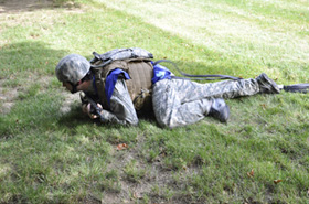 Soldier crawling wearing vest, body armor and blue sensor pads